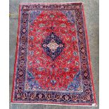 A Kashan carpet, Persian, the madder field with an indigo medallion, pale indigo spandrels,