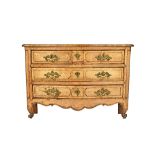 A Louis XV bleached oak commode of two short and two long serpentine drawers on squat scroll