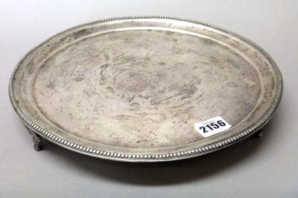 A Spanish circular salver, decorated with a beaded rim, raised on three shaped feet,