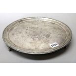 A Spanish circular salver, decorated with a beaded rim, raised on three shaped feet,