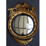 A Victorian gilt framed convex wall mirror with eagle surmount, 63cm wide x 92cm high.