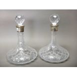 A pair of silver mounted moulded glass ship's decanters, on circular bases, height 26.5cm.
