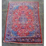 A Kashan carpet, Persian, the madder field with an indigo diamond medallion, pale indigo spandrels,