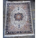 An Indian carpet, the ivory field with a bold dark indigo lobed medallion, beige spandrels,