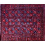 An Afghan Esari carpet, the dark madder field with three columns of six bold guls,