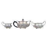 A late Victorian silver three piece tea set, comprising; a teapot,