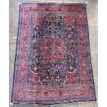 A large Tabriz carpet, Persian, the dark indigo field with a bold madder floral roundel,