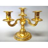 A French silver gilt three light table candelabrum,