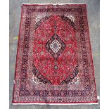 A Kashan carpet, Persian, the madder field with a dark indigo, ivory and light indigo medallion,