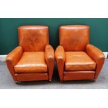 A pair of early 20th century French tanned leather easy armchairs on tapering square supports,