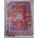 A Joshaghan carpet, Persian, the madder field with central indigo medallion,