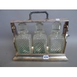 A silverplated three bottle cased tantalus, early 20th century, with locking mechanism,