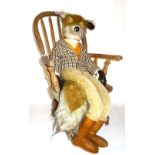 A 20th century toy fox wearing country clothing, seated on a child's ash and elm bow back armchair.