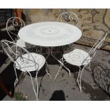 A 20th century French white painted metal circular wire work garden table with four matching chairs,