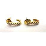 A pair of gold and diamond set earrings, each in a curved design,