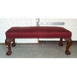 An early 20th century mahogany rectangular footstool on ball and claw feet, 92cm wide x 32cm high.