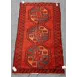 An Afghan Ersari rug, the madder field with three bold single medallions, a diamond border,