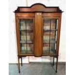 An early 20th century mahogany two door display cabinet on tapering square supports,