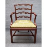 A George III style mahogany pierced wavy ladder back carver chair on canted block supports,