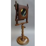 A late 19th century mahogany Zograscope with a hinged magnifier over an adjustable turned central
