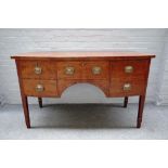 A George III mahogany bowfront sideboard with five frieze drawers on tapering square supports,