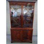 A George III mahogany bookcase cabinet, the pair of astragal glazed doors over a panel lower,