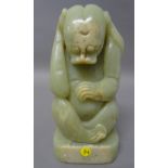 A Ming style celadon jade carving of a mythical creature, modelled seated with right paw to its ear,