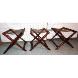 Pakeen; a set of three 20th century mahogany and leather luggage stands, 63cm wide x 50cm high, (3).