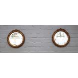 A pair of late 19th century gilt framed mirrors, each with foliate chased circular frames,