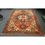 An Heriz carpet, Persian, the madder field with a bold angular pole medallion, ivory spandrels,