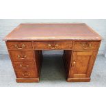A 19th century well figured pitch pine pedestal desk with six drawers and single cupboard about the