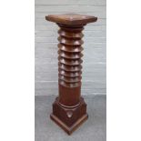 A jardinière stand with square top and base, the column taken form from a carved woodpress worm,