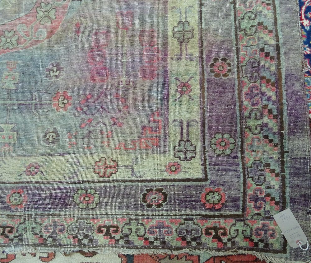 A Khotan carpet, ,the faded purple field with three bold roundels, - Image 7 of 7