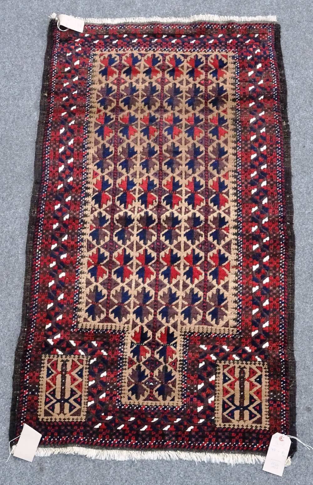 A Beluchistan prayer rug, the pale brown mehrab with matching three columns of flowering spandrels,
