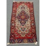 A Bakhtiari rug, reduced, Persian, the ivory field with an indigo medallion, madder spandrels,