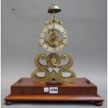 A brass skeleton mantel clock, 20th century of typical open frame form, with bell surmount,