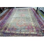 A Khotan carpet, ,the faded purple field with three bold roundels,