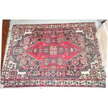 A Bakhtiari rug, the black field with a bold madder medallion, angular motifs and flowerheads,