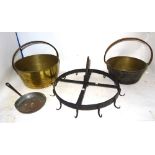 A similar pair of brass jam pans with swing handles and a wrought iron game hanging rack.