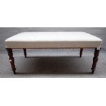 A 19th century style rectangular footstool on mahogany baluster supports,