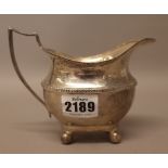 A silver milk jug, of helmet shaped form, having a reeded handle,