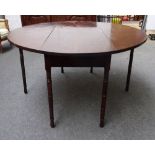 A Regency mahogany dining table, the oval drop flap top on ring turned supports,