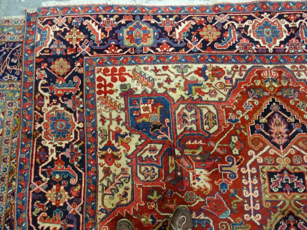A Heriz carpet, Persian, the madder field with a bold central medallion, ivory spandrels, - Image 5 of 5