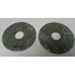 A pair of Chinese spinach jade bi discs, the stone with cream inclusions, 12cm. diameter, (2).