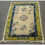 A Chinese carpet, the ivory field with a central roundel, floral sprays,