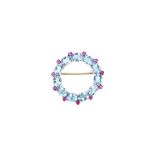 A ruby and aquamarine brooch, in an openwork circular design,