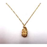 A gold pendant formed as an Egyptian scarab beetle, with a gold neckchain, on a boltring clasp,