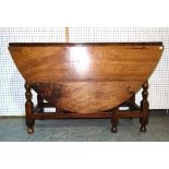 An 18th century oak and walnut gateleg table with single drawer on block supports,