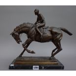A modern bronze depicting horse and jockey on a naturalistic rectangular base and black marble