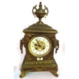A late 19th century French 8 day metal cased clock, 40cm high with urn finial.